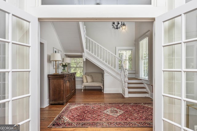 entrance foyer featuring stairway, wood finished floors, and high vaulted ceiling