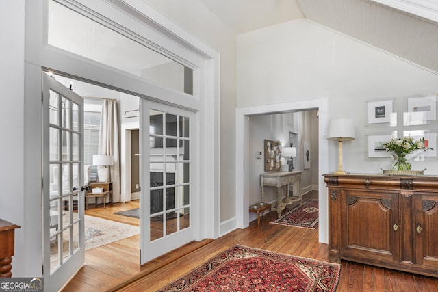 interior space with dark wood-type flooring, french doors, baseboards, and high vaulted ceiling