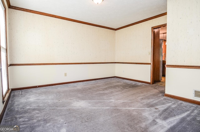 unfurnished room with visible vents, baseboards, carpet, and ornamental molding