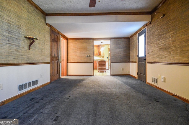 empty room with visible vents, a textured ceiling, and carpet floors