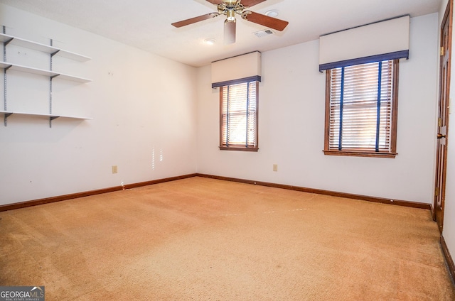 empty room featuring visible vents, baseboards, light colored carpet, and ceiling fan