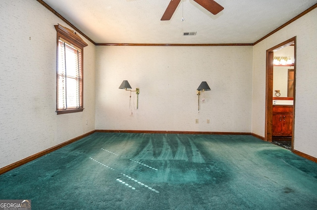 spare room with visible vents, carpet floors, crown molding, baseboards, and ceiling fan