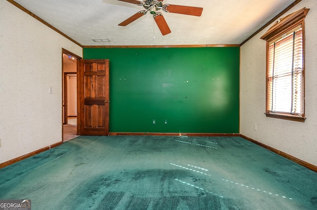 carpeted spare room featuring ceiling fan, a textured ceiling, baseboards, and ornamental molding