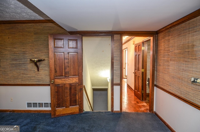 corridor featuring visible vents, an upstairs landing, baseboards, and ornamental molding