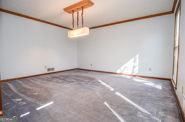 carpeted spare room featuring visible vents, crown molding, and baseboards