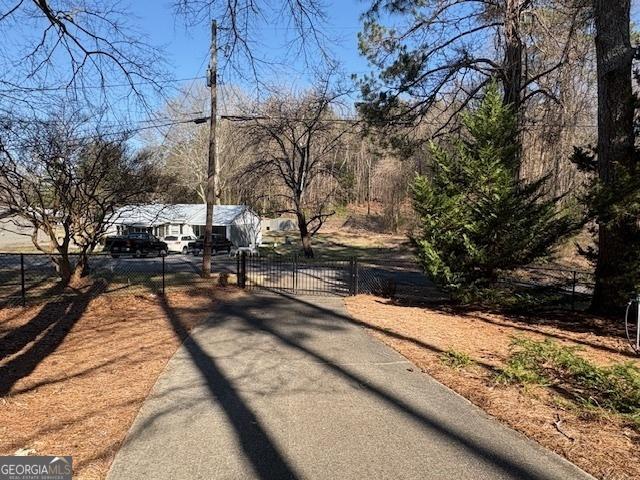 view of street with a gated entry, driveway, and a gate