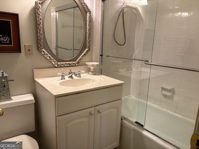 full bathroom featuring enclosed tub / shower combo, toilet, and vanity