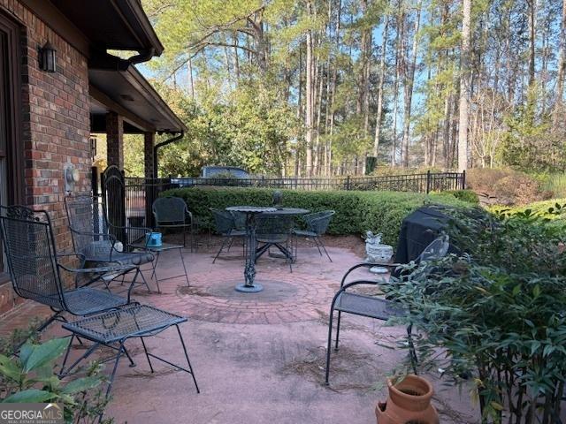 view of patio featuring outdoor dining space and fence