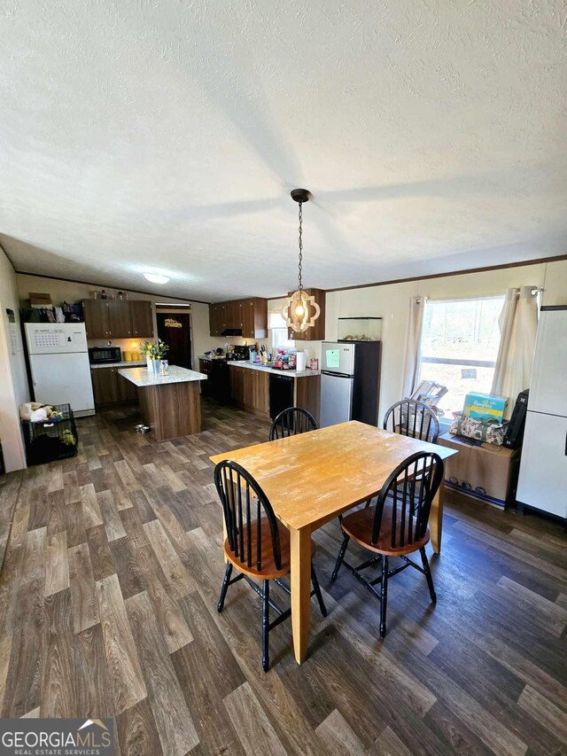 dining area featuring a textured ceiling and dark wood-style floors