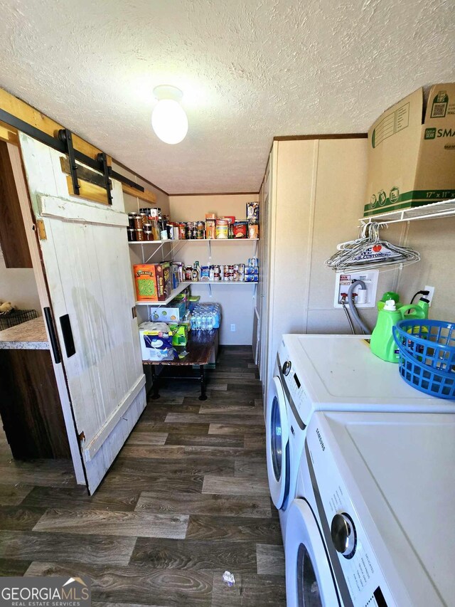 laundry room featuring dark wood finished floors, laundry area, a textured ceiling, and washing machine and clothes dryer