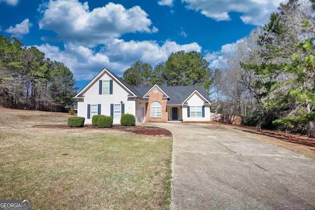 view of front of house with a front lawn, fence, concrete driveway, a garage, and brick siding