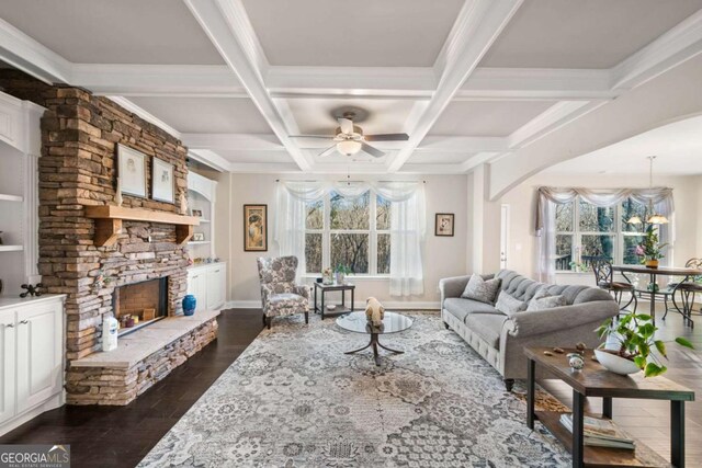 living room with coffered ceiling, a fireplace, ceiling fan, dark wood-type flooring, and beamed ceiling