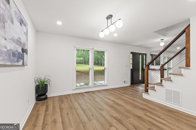 entryway featuring wood finished floors, stairs, baseboards, visible vents, and recessed lighting