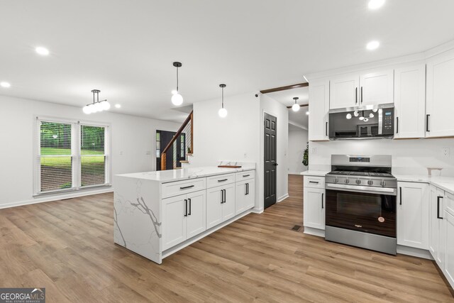kitchen featuring stainless steel appliances, a peninsula, recessed lighting, and light wood-style flooring