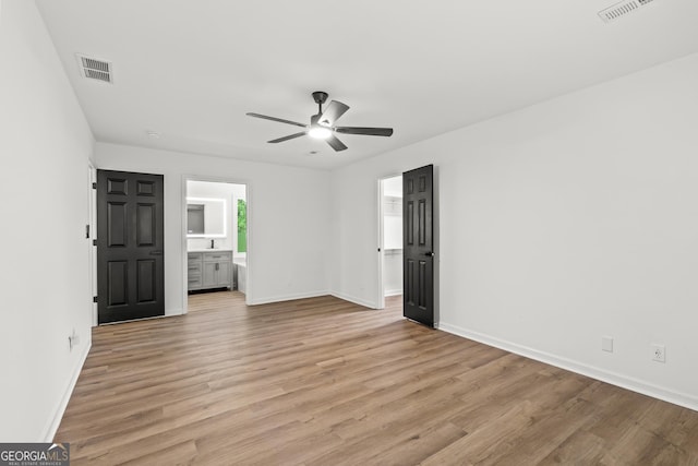 spare room featuring light wood finished floors, visible vents, and a ceiling fan