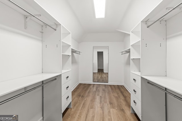 spacious closet featuring vaulted ceiling and light wood-style flooring