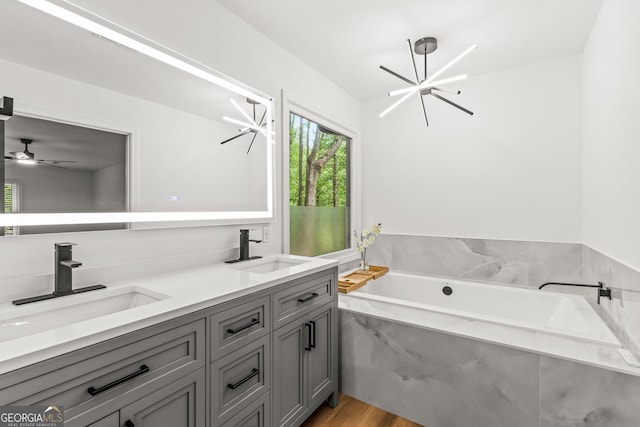 full bath featuring a garden tub, wood finished floors, a sink, and double vanity