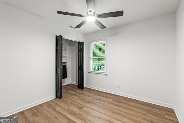 unfurnished bedroom with a ceiling fan, baseboards, and light wood-style floors