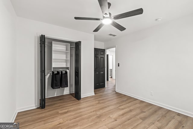 unfurnished bedroom with a closet, ceiling fan, light wood-style flooring, baseboards, and visible vents