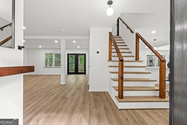 stairs with recessed lighting, wood finished floors, baseboards, and french doors