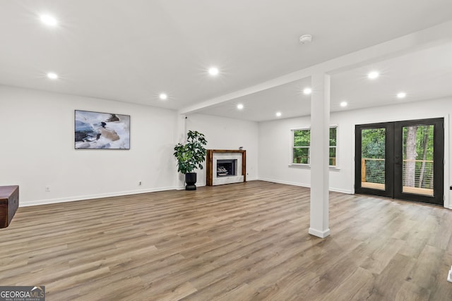 unfurnished living room featuring recessed lighting, light wood-style flooring, and baseboards