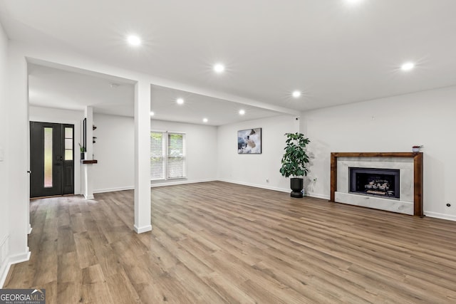 unfurnished living room with a fireplace, wood finished floors, and recessed lighting