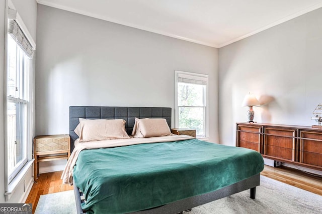 bedroom featuring wood finished floors and ornamental molding