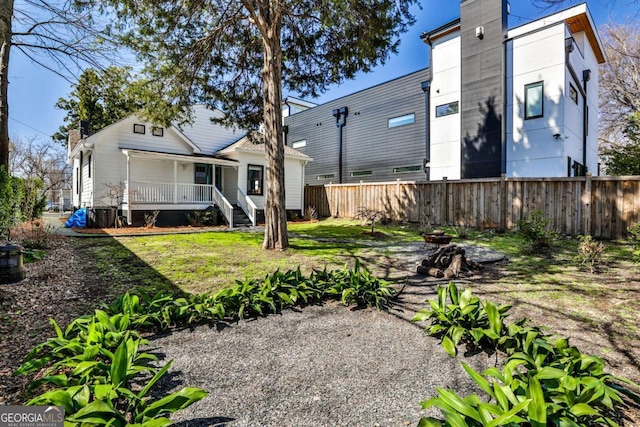 back of property with a porch and fence