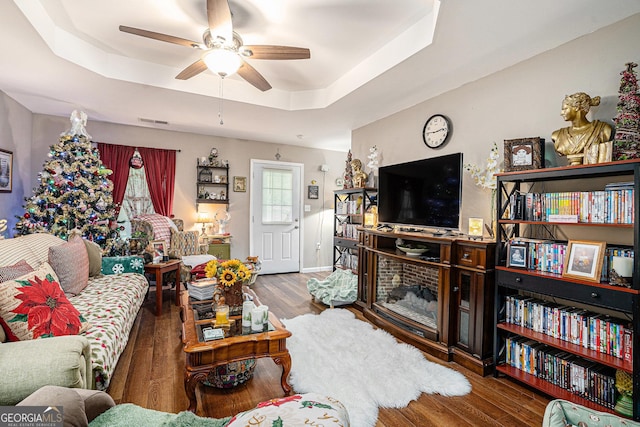 410 Bowen Rd NE, White, GA 30184 - living room featuring a healthy amount of sunlight, ceiling fan, a tray ceiling, and wood finished floors