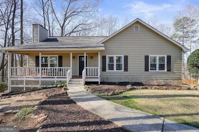 view of front of property featuring a porch, a front yard, and a chimney