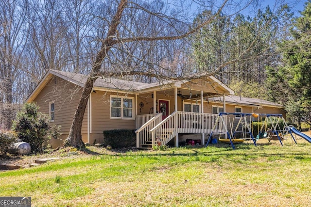 ranch-style home featuring ceiling fan, a playground, and a front yard