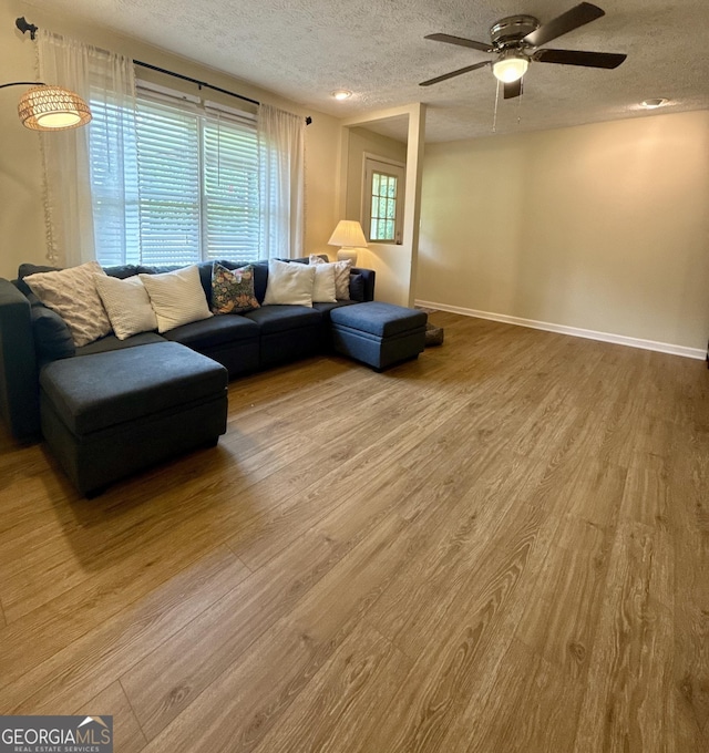 1537 David Lee St, Acworth, GA 30102 - living area with a textured ceiling, wood finished floors, ceiling fan, and baseboards