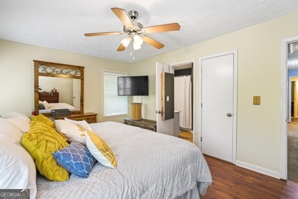 bedroom with baseboards, ceiling fan, and wood finished floors