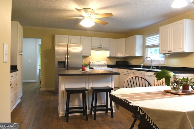 1537 David Lee St, Acworth, GA 30102 - kitchen featuring white range with electric cooktop, under cabinet range hood, a sink, dark countertops, and stainless steel refrigerator with ice dispenser