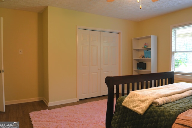 1537 David Lee St, Acworth, GA 30102 - bedroom with wood finished floors, a closet, baseboards, a textured ceiling, and a ceiling fan