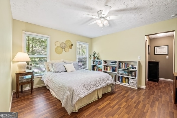 bedroom featuring baseboards, a ceiling fan, and dark wood-style floors