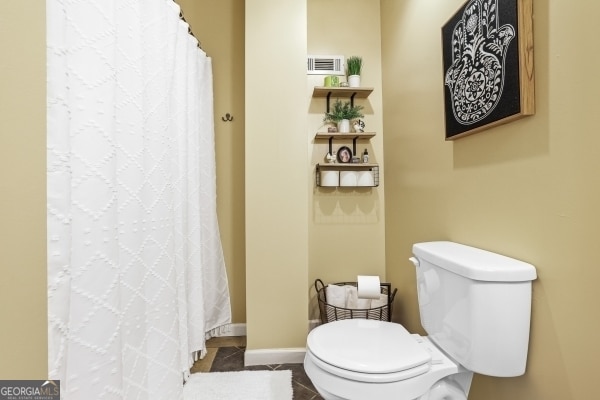 full bathroom featuring toilet, tile patterned floors, a shower with shower curtain, and visible vents