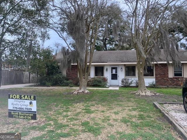 ranch-style house with a front lawn, fence, and brick siding