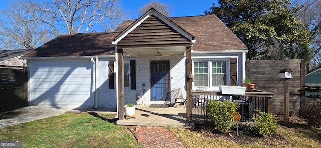 view of front of home with brick siding, a shingled roof, a ceiling fan, and fence