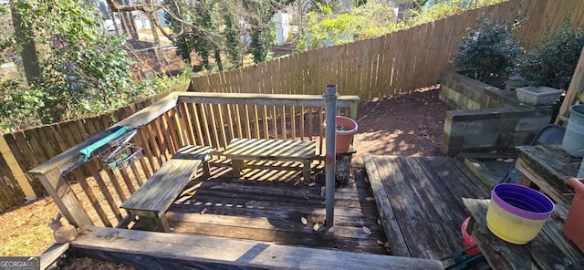 wooden terrace with a fenced backyard