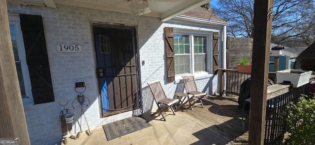 entrance to property with brick siding and ceiling fan