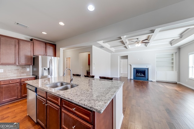 kitchen featuring visible vents, a sink, coffered ceiling, wood finished floors, and stainless steel appliances