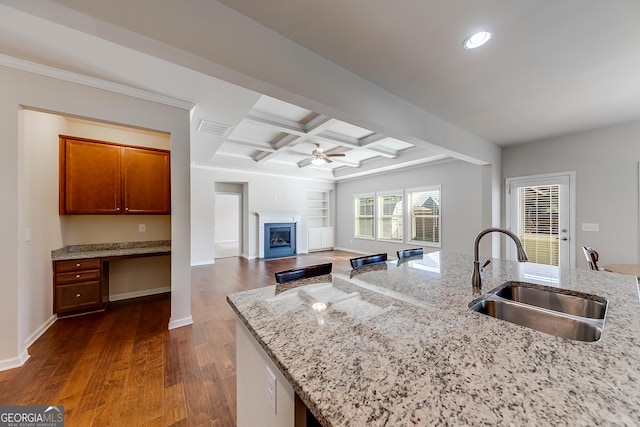 kitchen with visible vents, ceiling fan, built in desk, coffered ceiling, and a sink