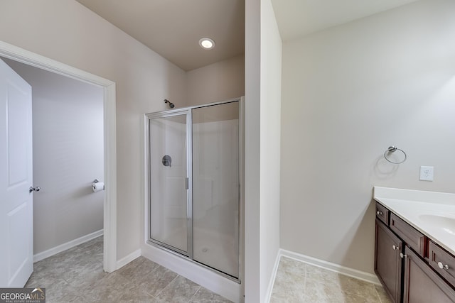 full bath with baseboards, a stall shower, and vanity