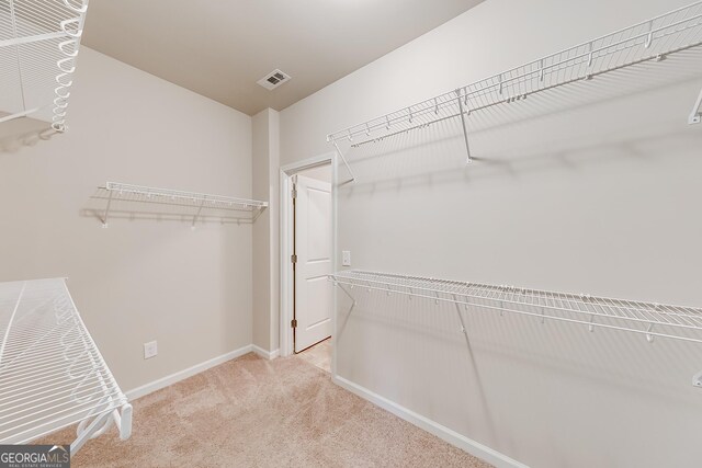 spacious closet featuring visible vents and carpet floors