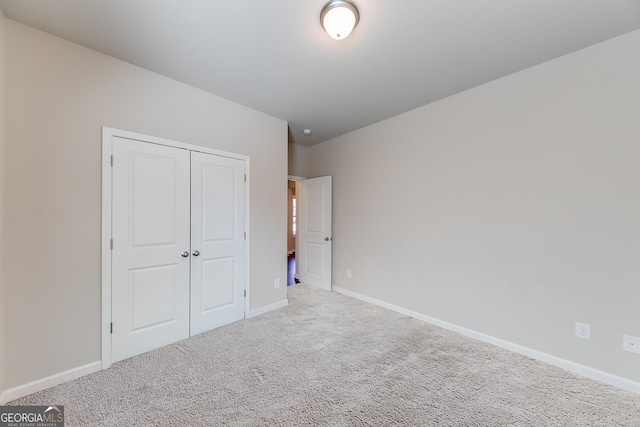 unfurnished bedroom with a closet, baseboards, and carpet floors