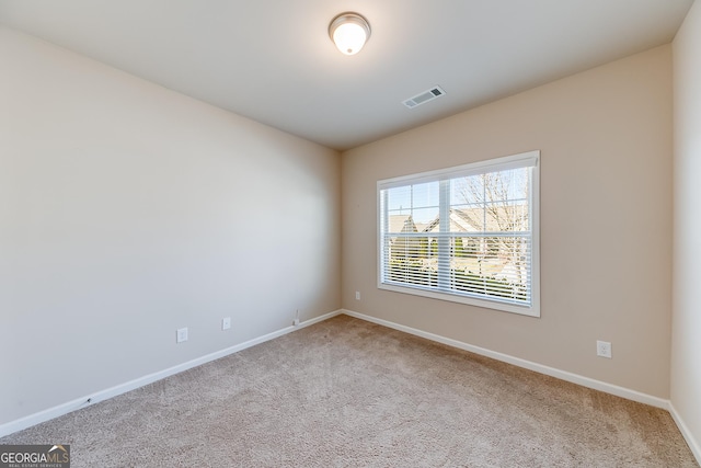 empty room featuring visible vents, baseboards, and carpet flooring