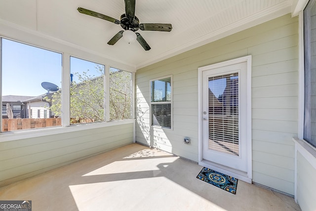 unfurnished sunroom featuring ceiling fan