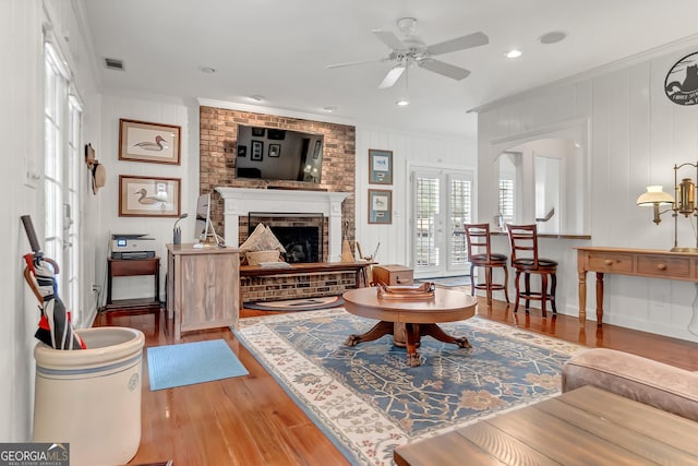 living area featuring visible vents, wood finished floors, ornamental molding, and french doors