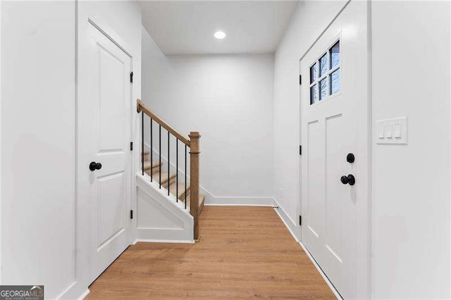 foyer entrance featuring recessed lighting, baseboards, light wood-style flooring, and stairs